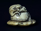 Netsuke in the form of a rain dragon coiled around a mokugyō, a Buddhist percussion instrument
