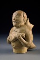 Figure of a musician carrying a water-skin