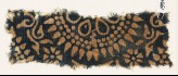 Textile fragment with part of a large rosette, surrounded by dots and petals