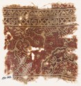 Textile fragment with ornate floral design and a large half-medallion
