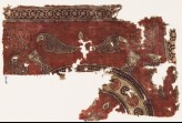 Textile fragment with stylized plants in pots, and a large circular design