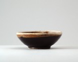 Black ware bowl with russet iron splashes and a white rim