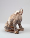 Figure of a lion scratching its head