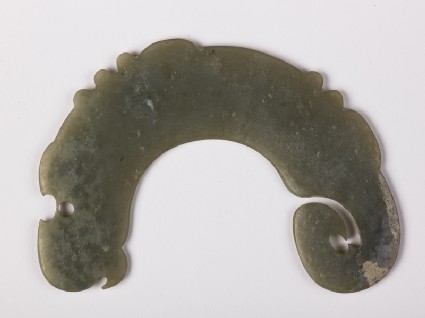 Notched pendant in the form of a dragonfront