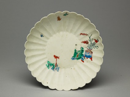 Fluted saucer depicting a boy, probably trying to catch a birdtop