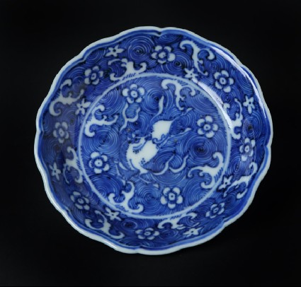 Blue-and-white dish with horse amid waves, and Prunus blossomsfront