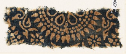 Textile fragment with part of a large rosette, surrounded by dots and petalsfront