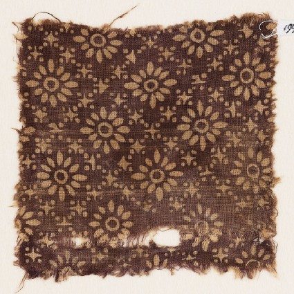 Textile fragment with rosettes in a grid of stars and dotsfront