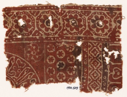 Textile fragment with rosettes in dotted frames, linked diamond-shapes, and Arabic inscriptionfront