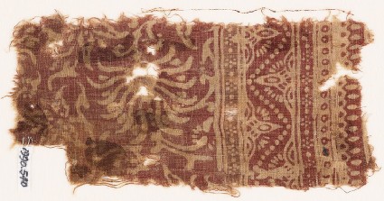 Textile fragment with swirling flower-heads and a dotted zigzagfront