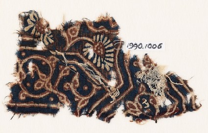 Textile fragment with curving tendril, leaves, and a flowerfront