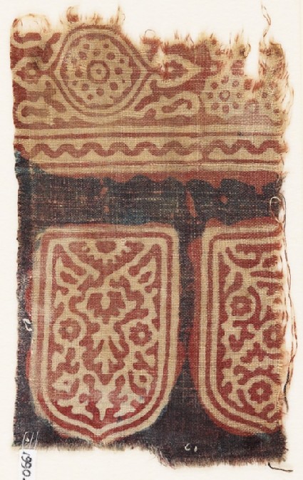 Textile fragment with tab-shapes, linked rosettes, and an ovalfront