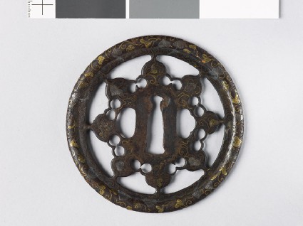 Round tsuba with karakusa, or scrolling plant pattern, interspersed with aoi, or hollyhock leavesfront