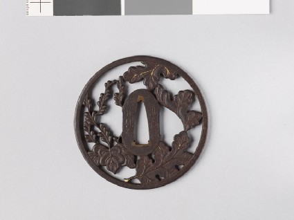 Round tsuba with chrysanthemum leaves and mon made from kiri, or paulownia leavesfront