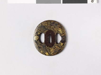 Lenticular tsuba with figures and animals amid flowersfront