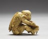Netsuke in the form of a man making a mat (side)