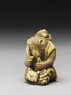 Netsuke in the form of a monkey holding a crab (side)