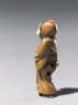 Netsuke in the form of a figure wearing a mask of Okame, a merry Shinto goddess (side)