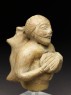 Figure of a musician carrying a water-skin (oblique)