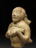 Figure of a musician carrying a water-skin (side)