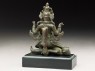 Seated figure of a crowned deity with four arms upon another figure (side)