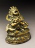 Seated figure of a male deity holding a bell and vajra, his head cocked back and mouth open, possibly an incense burner or pill dispenser (side)