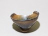 Black ware tea bowl with 'hare's fur' glazes, stuck to a firing pad (oblique)